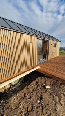 Mobilní chatka s terasovými dveřmi, které plní funkci vchodových dveří